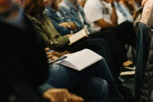woman reading book in training room with team members