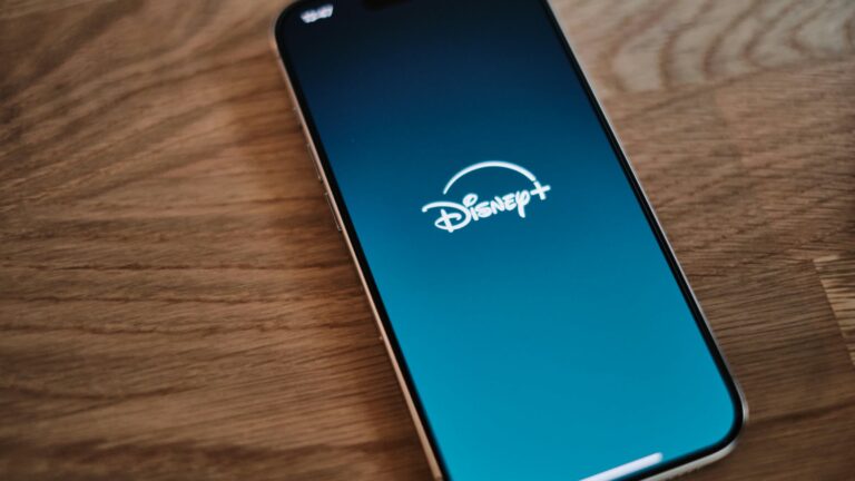 Disney+ app open on a smartphone resting on a wooden table
