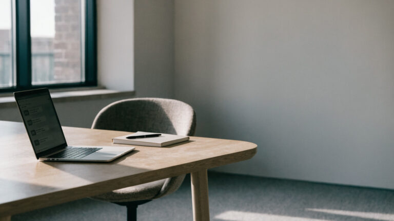 A tidy office desk with a laptop and notebook, representing workplace messaging tools and data protection governance