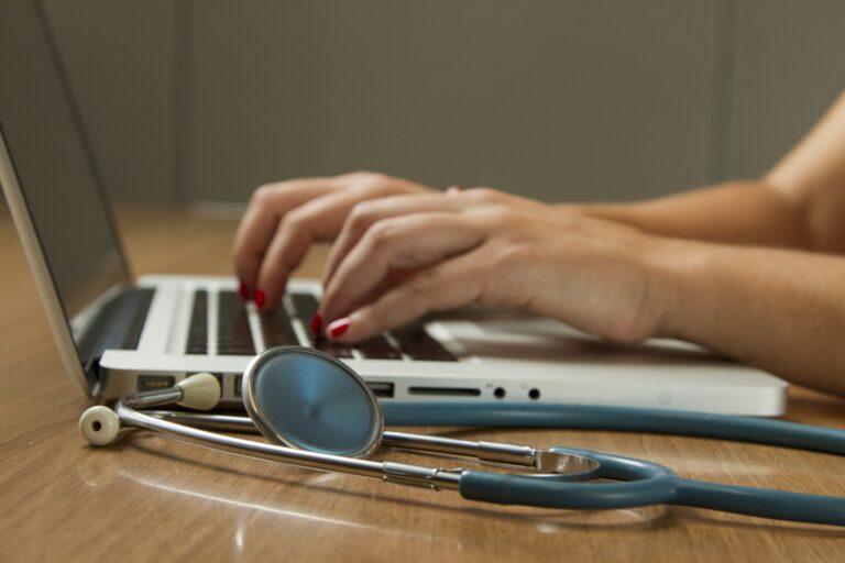 A stethoscope beside a laptop computer, representing the intersection of healthcare and data security