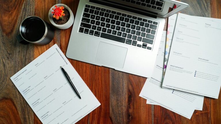 A laptop on a wooden desk with paperwork, representing an employee preparing a GDPR subject access request to their employer