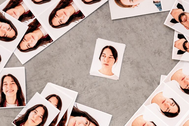 Printed portrait photographs arranged on a grey surface.