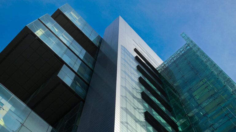 Looking up at the glass and metal facade of Manchester Civil Justice Centre